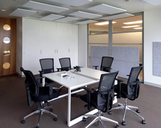 White Suspended Acoustic Ceiling panels & Acoustic V-Grooved wall Panels in Office meeting Room.